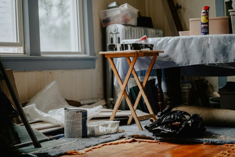 A person inspects a clean rental home with a checklist, keys, and safety equipment on a kitchen counter.